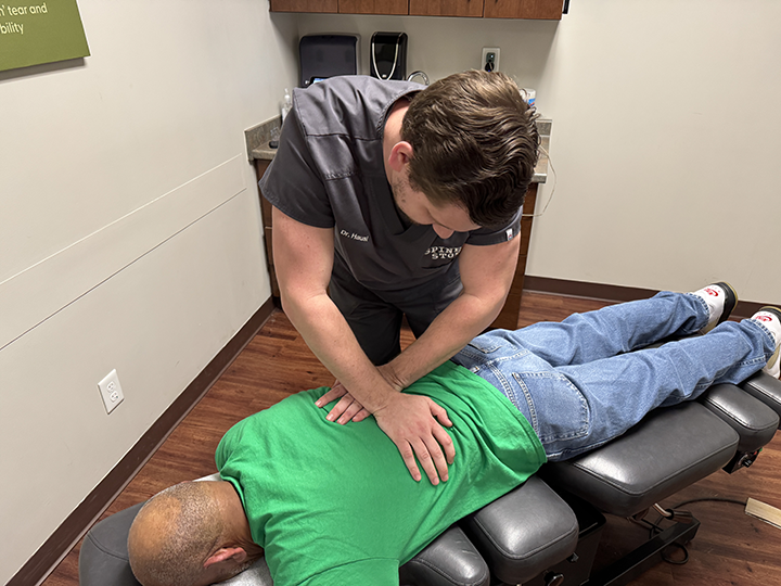 chiropractor doctor timothy hausl adjusts a patient's back