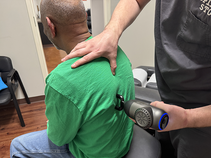 chiropractor doctor timothy hausl adjusts a patient's back using the arthorstim