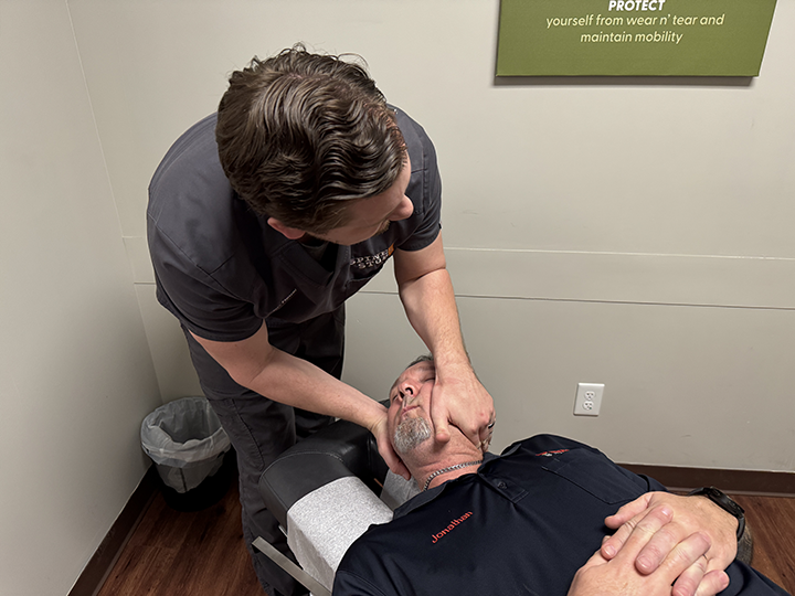 chiropractor doctor timothy hausl adjusts a patient's neck
