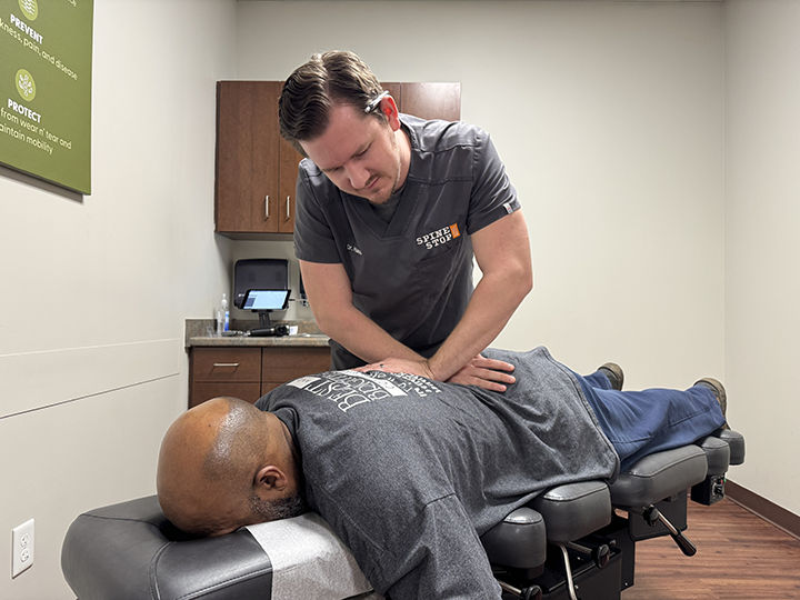chiropractor doctor timothy hausl adjusts a patient's back