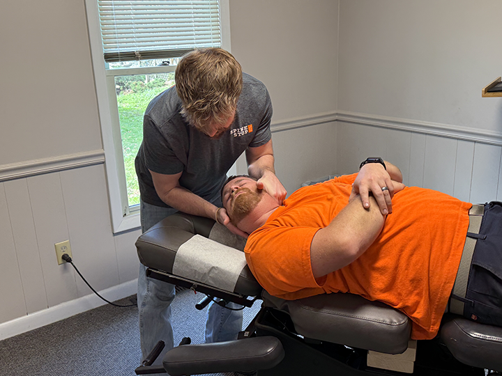 chiropractor dr. derrick witmer adjusts a patient's neck