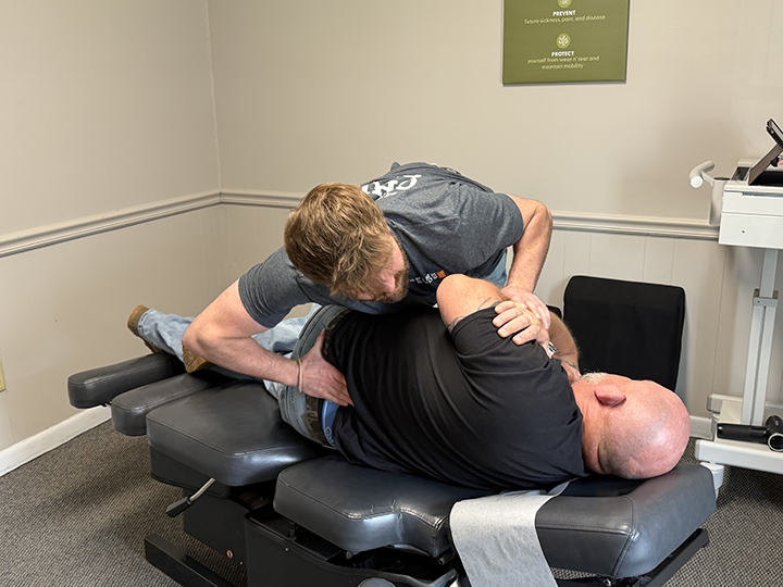 chiropractor dr. derrick witmer adjusts a patient's back