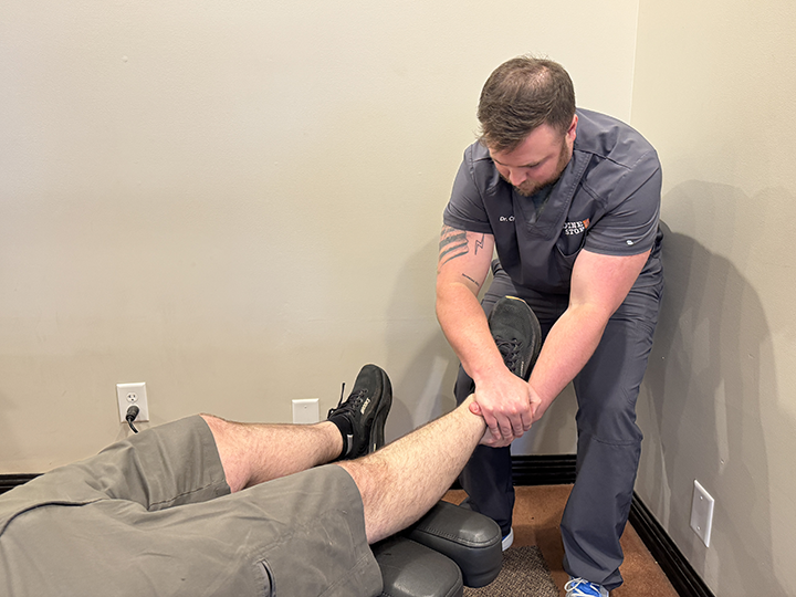 chiropractor dr. chavis adjusts a patient's leg