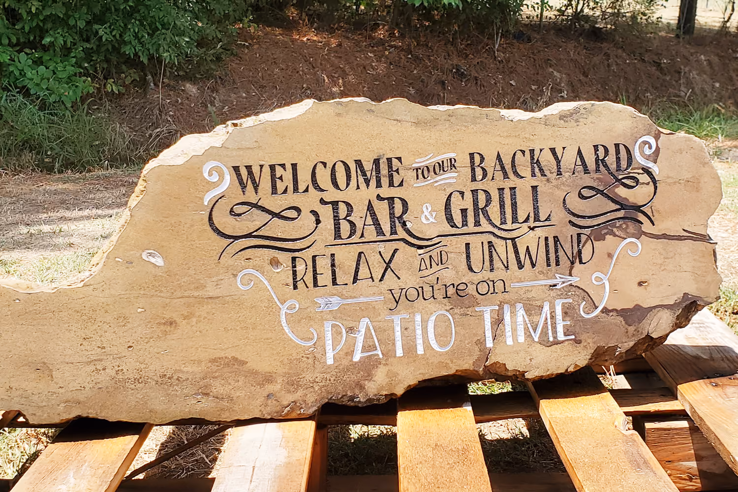 Engraved Stone with welcome to our backyard sign