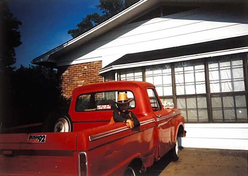 A dog sitting in the back of a red truck.