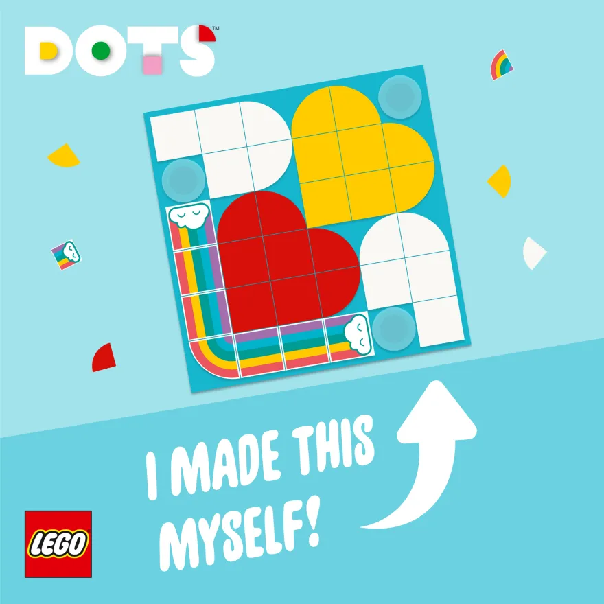 A LEGO DOTS design featuring a heart shape created with colorful tiles on a blue square board, surrounded by loose pieces and a caption celebrating personal creation.