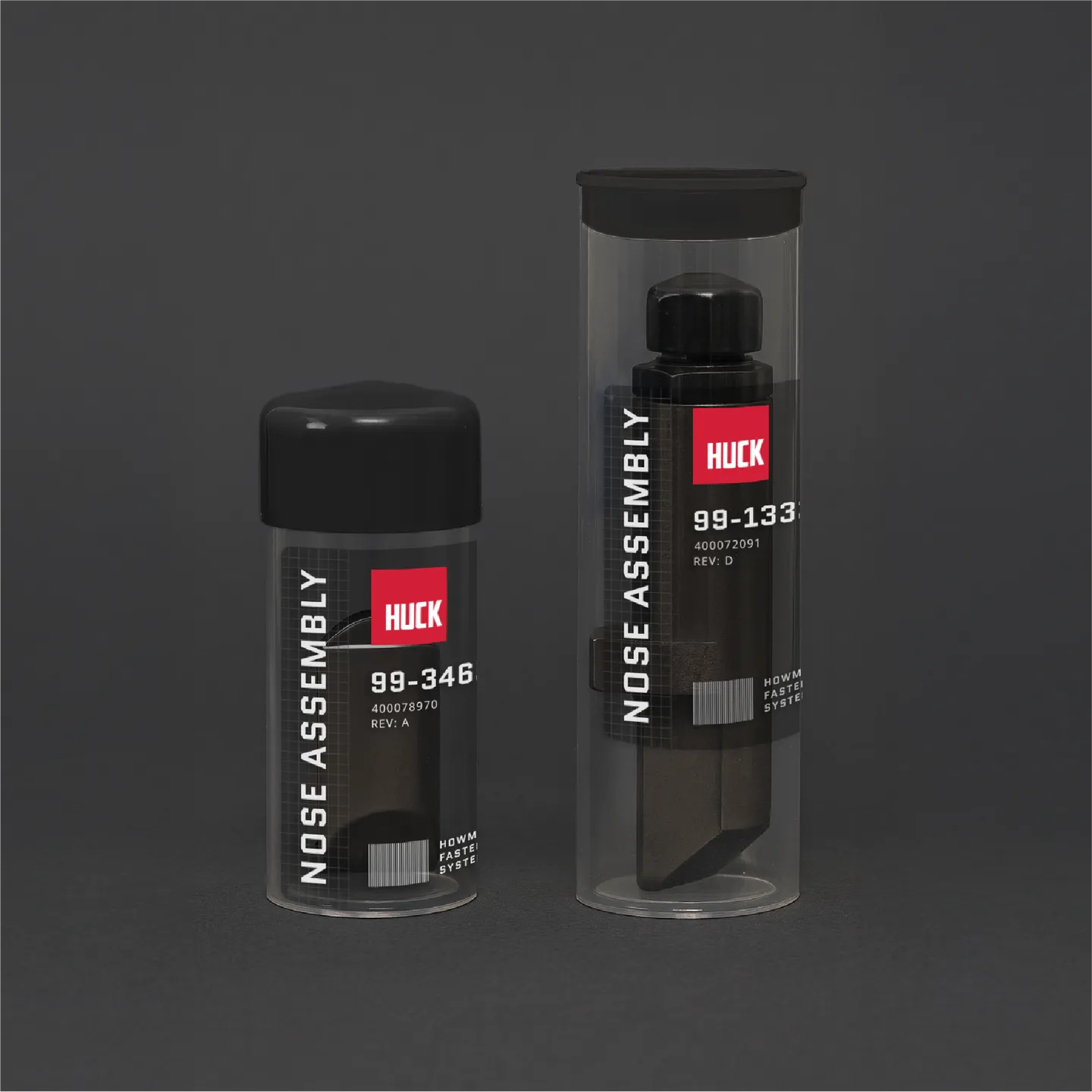 Two cylindrical containers labeled Huck Nose Assembly with black caps on a dark background.