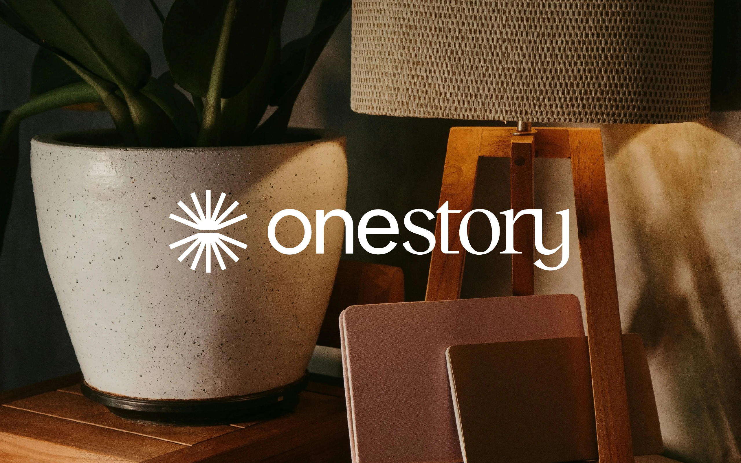 One Story logo over a warm interior scene with a journal and plants