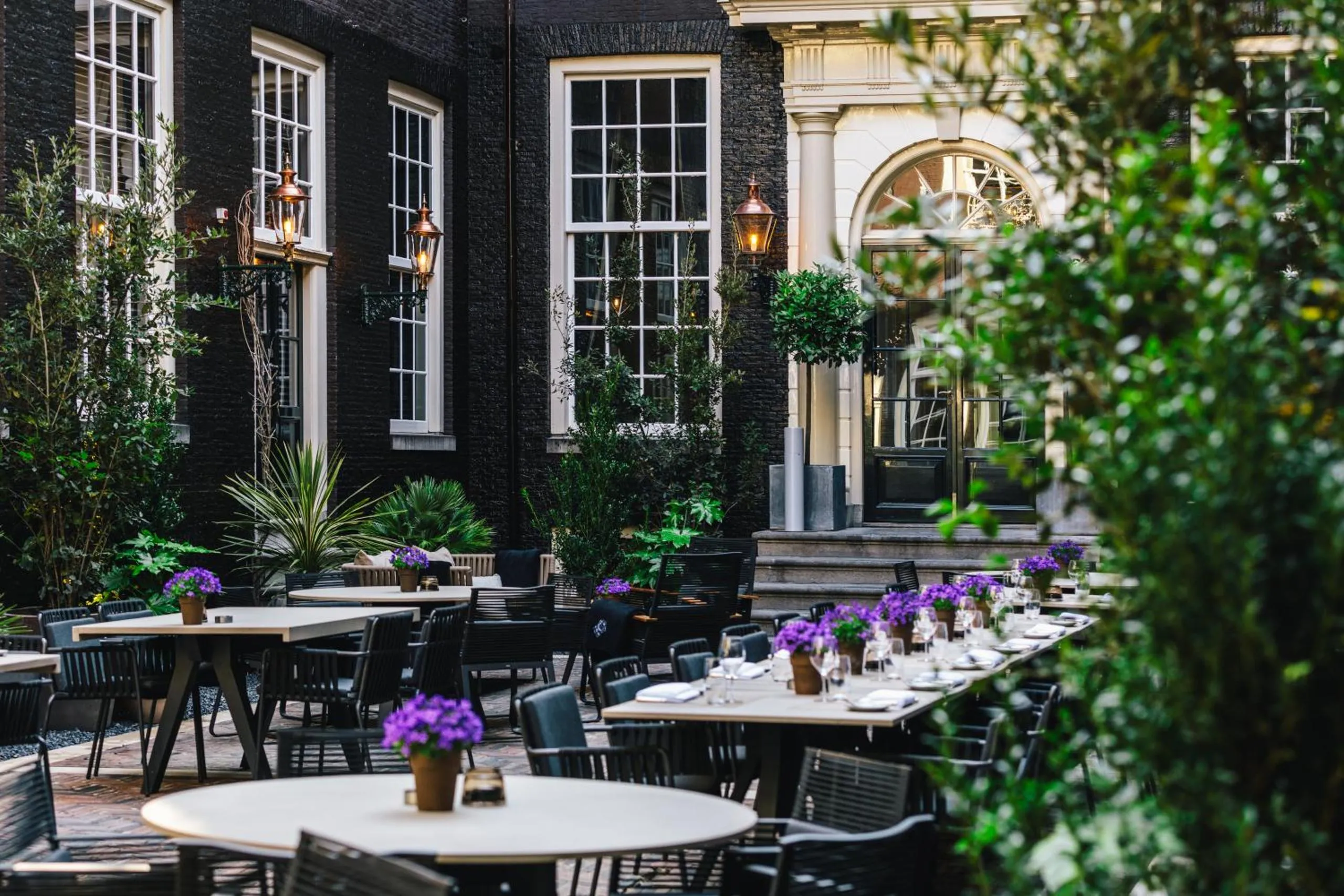 Bar Brasserie OCCO courtyard at The Dylan Amsterdam with copper lanterns and black brick facade