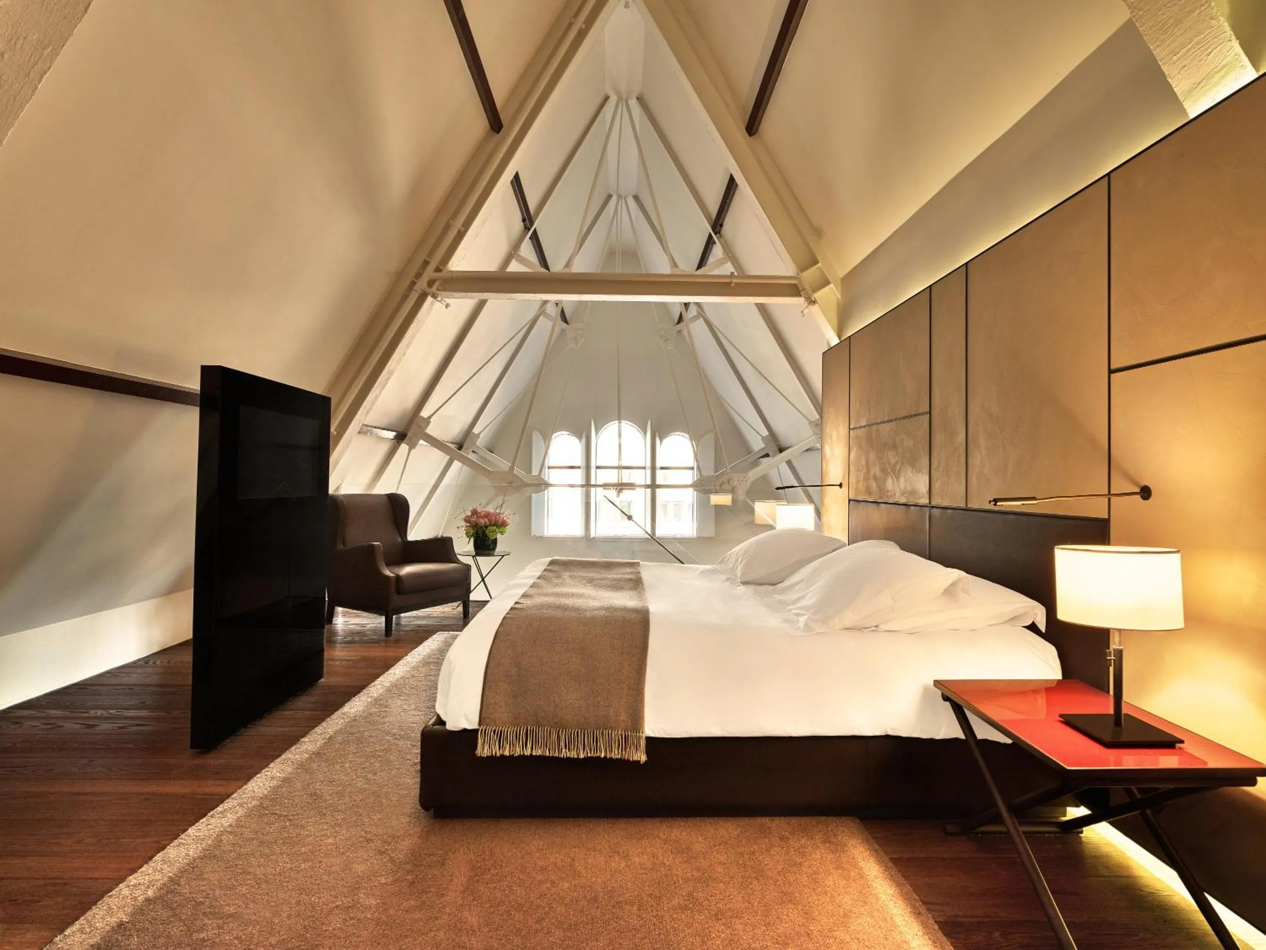 Conservatorium Amsterdam attic suite with A-frame timber trusses, leather panelling and pitched ceiling