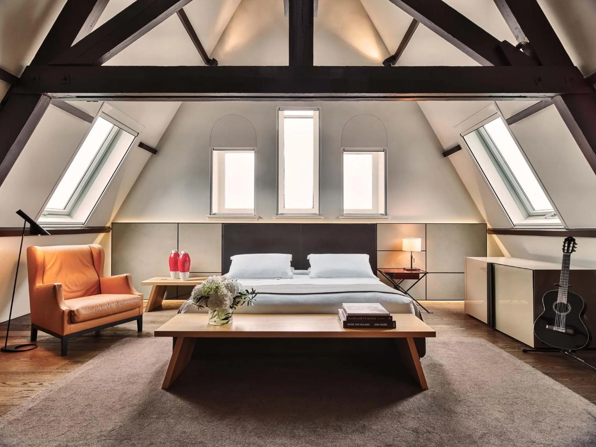 Conservatorium Amsterdam attic suite with A-frame timber trusses, leather panelling and pitched ceiling
