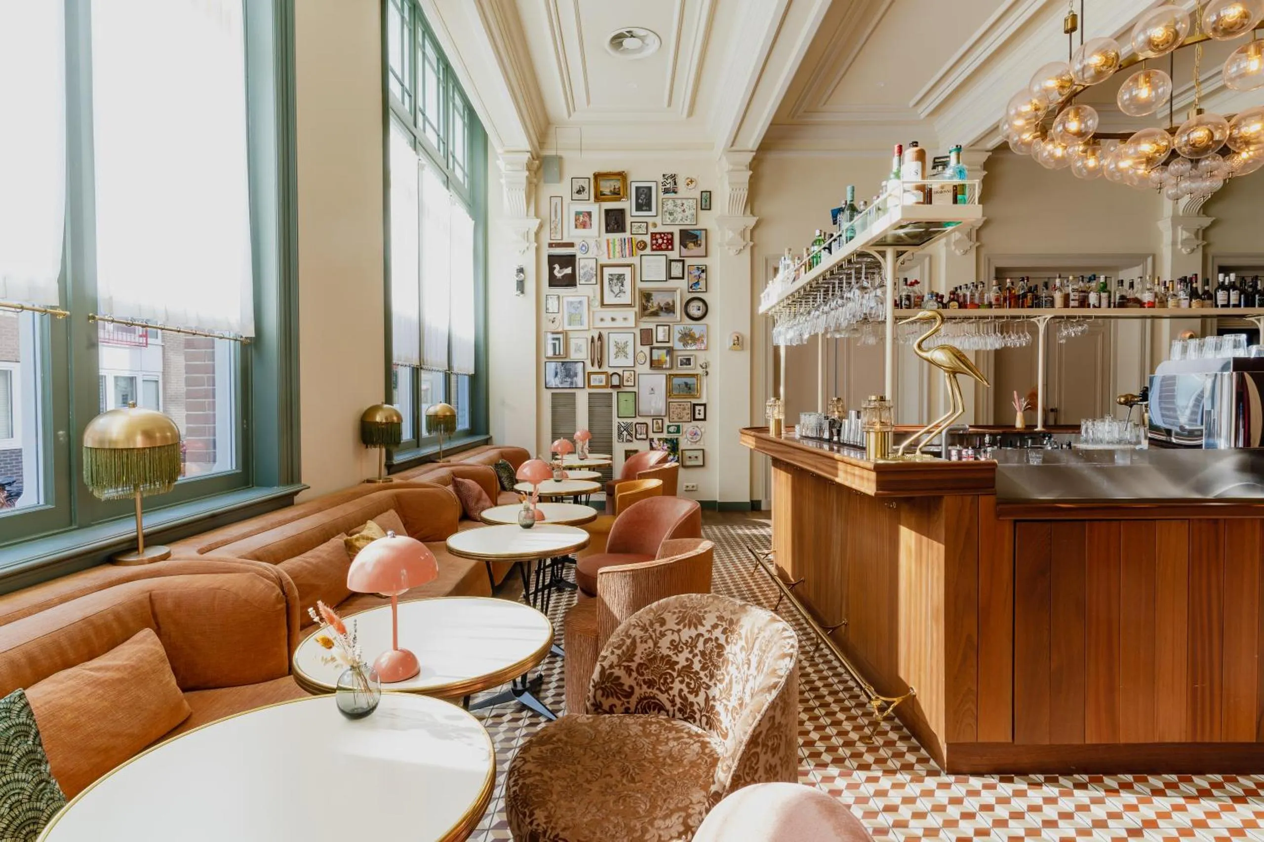 Hotel Mercier lounge with floor-to-ceiling gallery wall, terracotta banquette and globe chandelier
