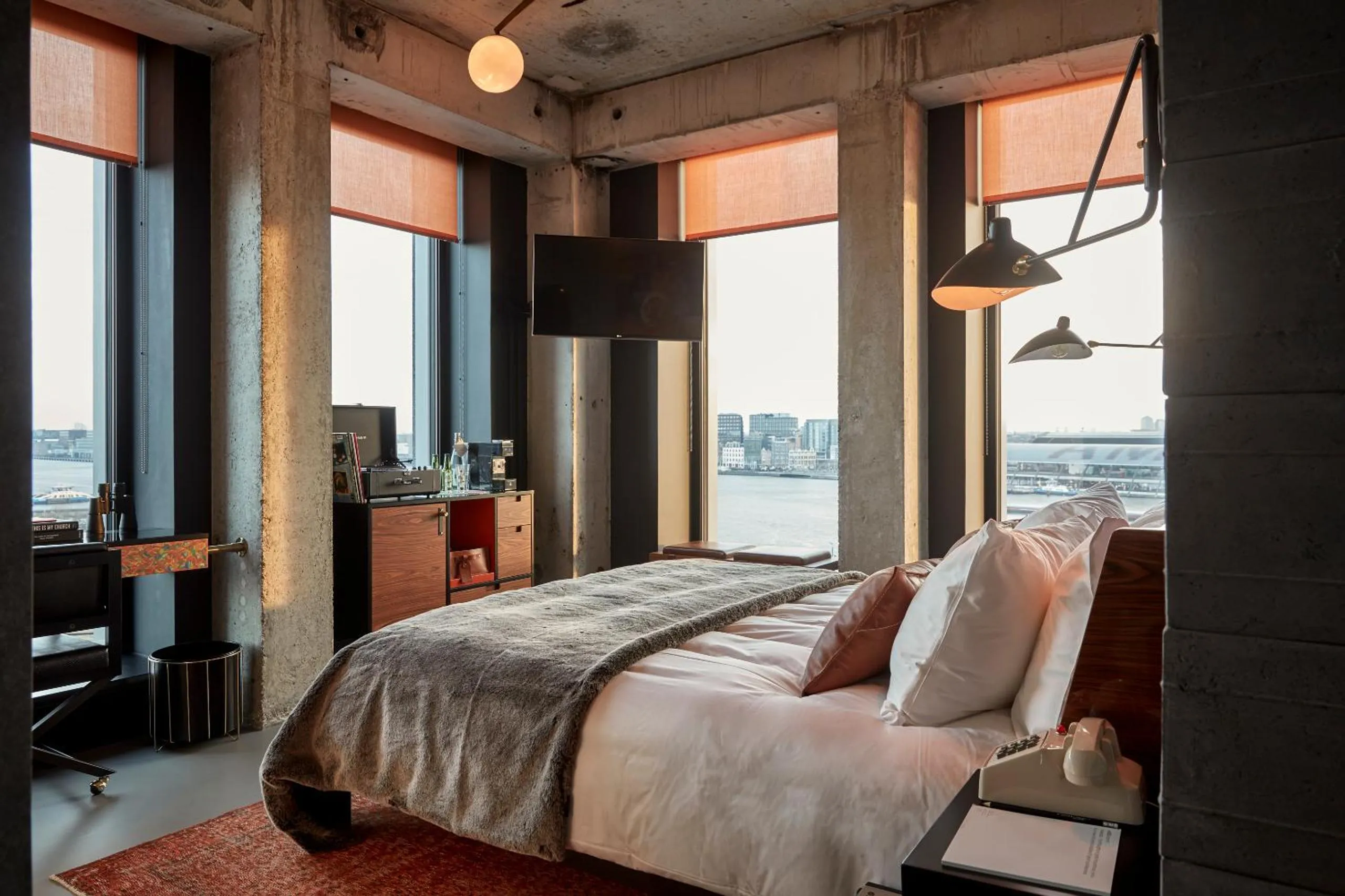 Sir Adam Hotel suite with exposed concrete columns, floor-to-ceiling windows and IJ-river view
