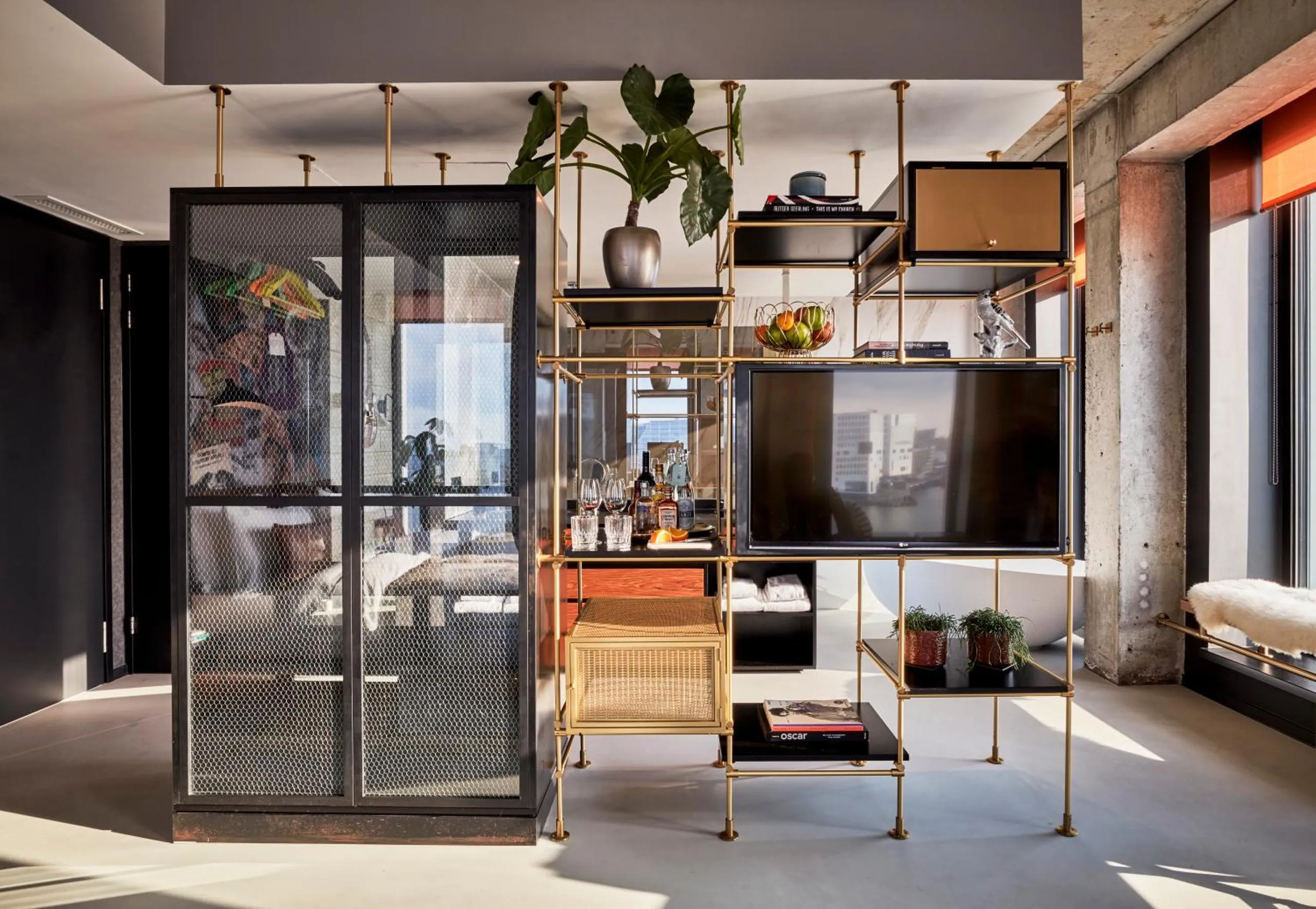 Sir Adam Hotel suite with brass modular shelving, freestanding tub and floor-to-ceiling windows