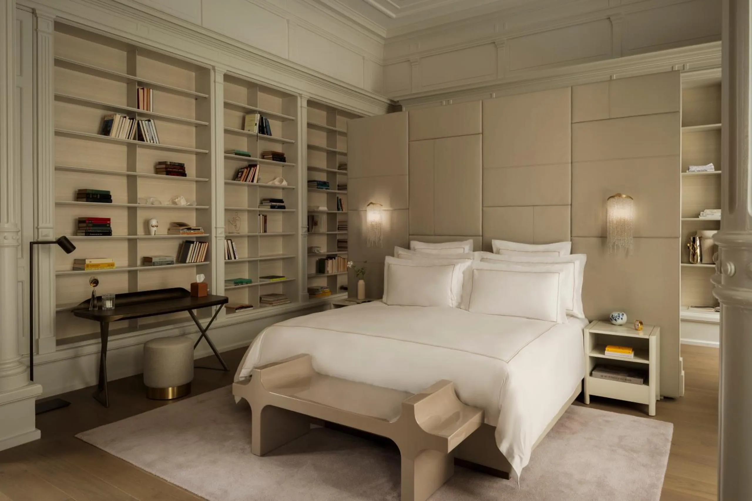 Rosewood Amsterdam suite with floor-to-ceiling library shelving, padded headboard and sculptural bench