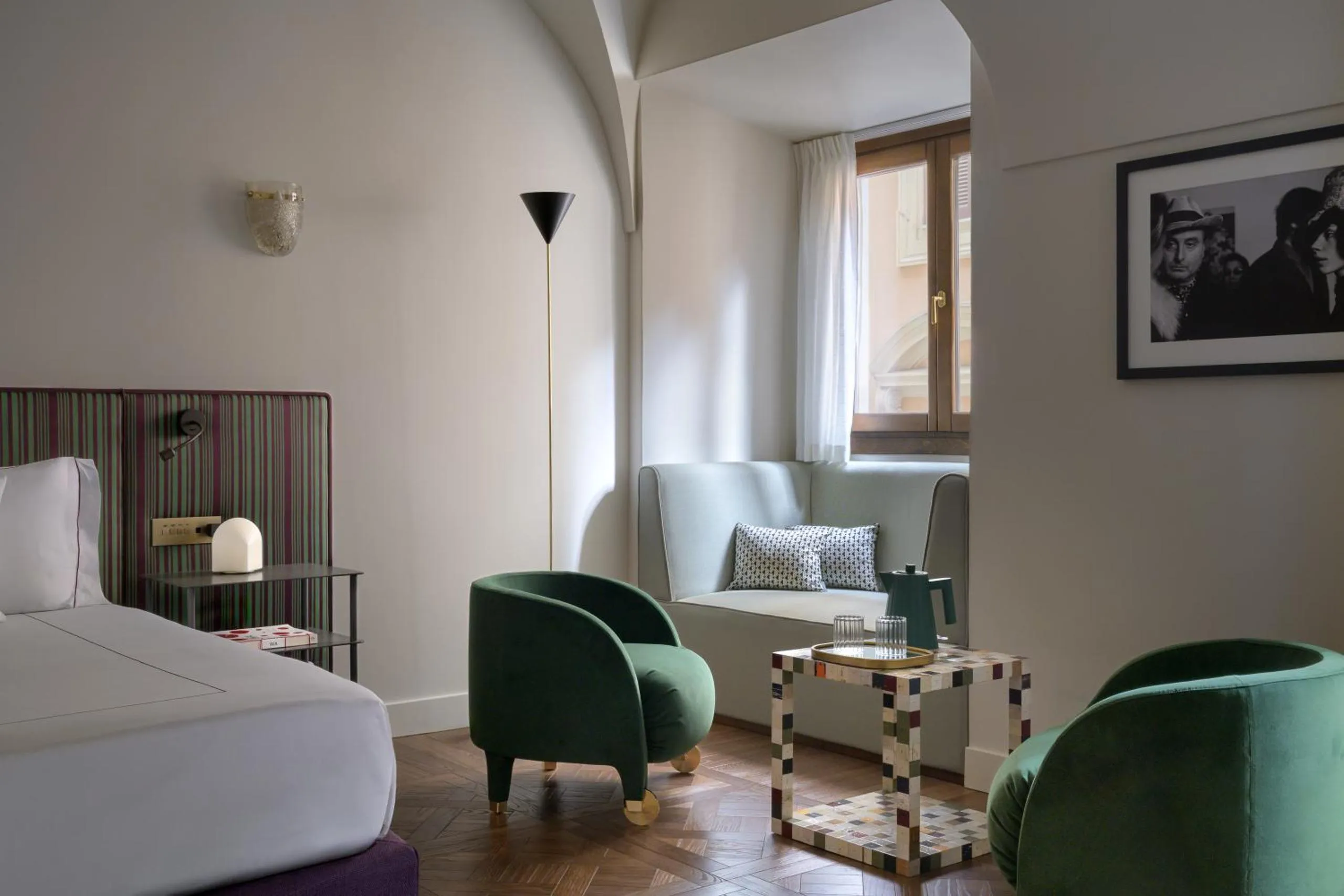 Palazzo Talìa suite with striped headboard, emerald velvet armchairs and herringbone parquet floor