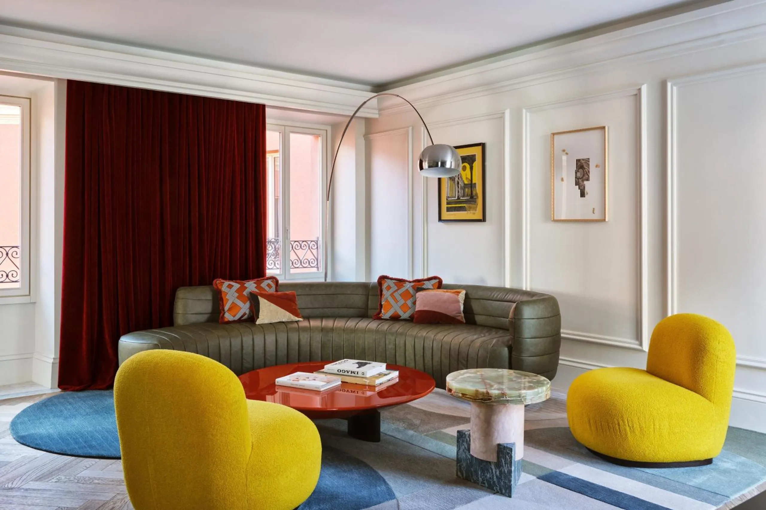 W Rome suite with curved leather sofa, yellow bouclé chairs and red lacquer coffee table