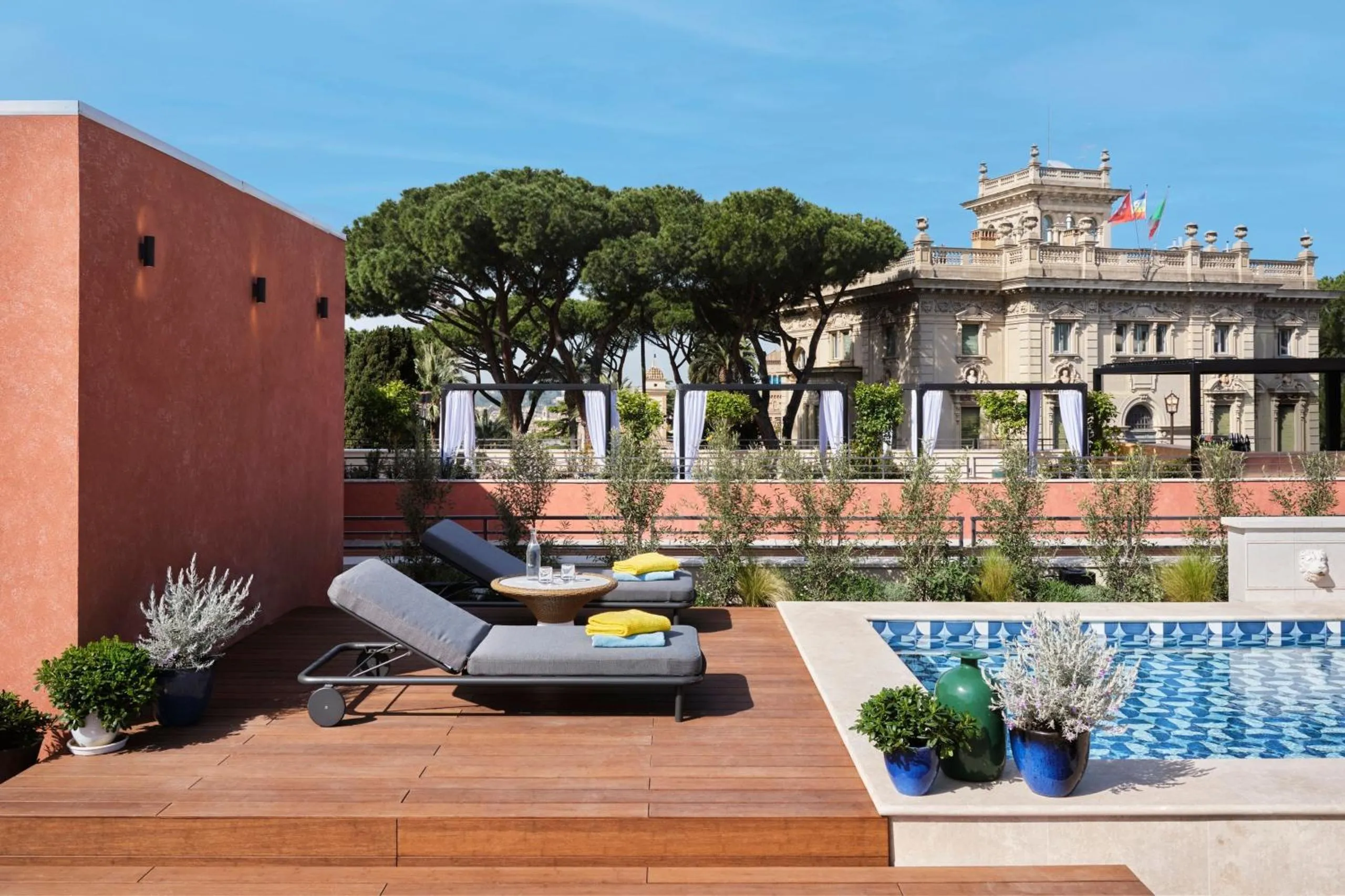 W Rome rooftop pool with mosaic tiling, sun loungers and views over Roman stone pines