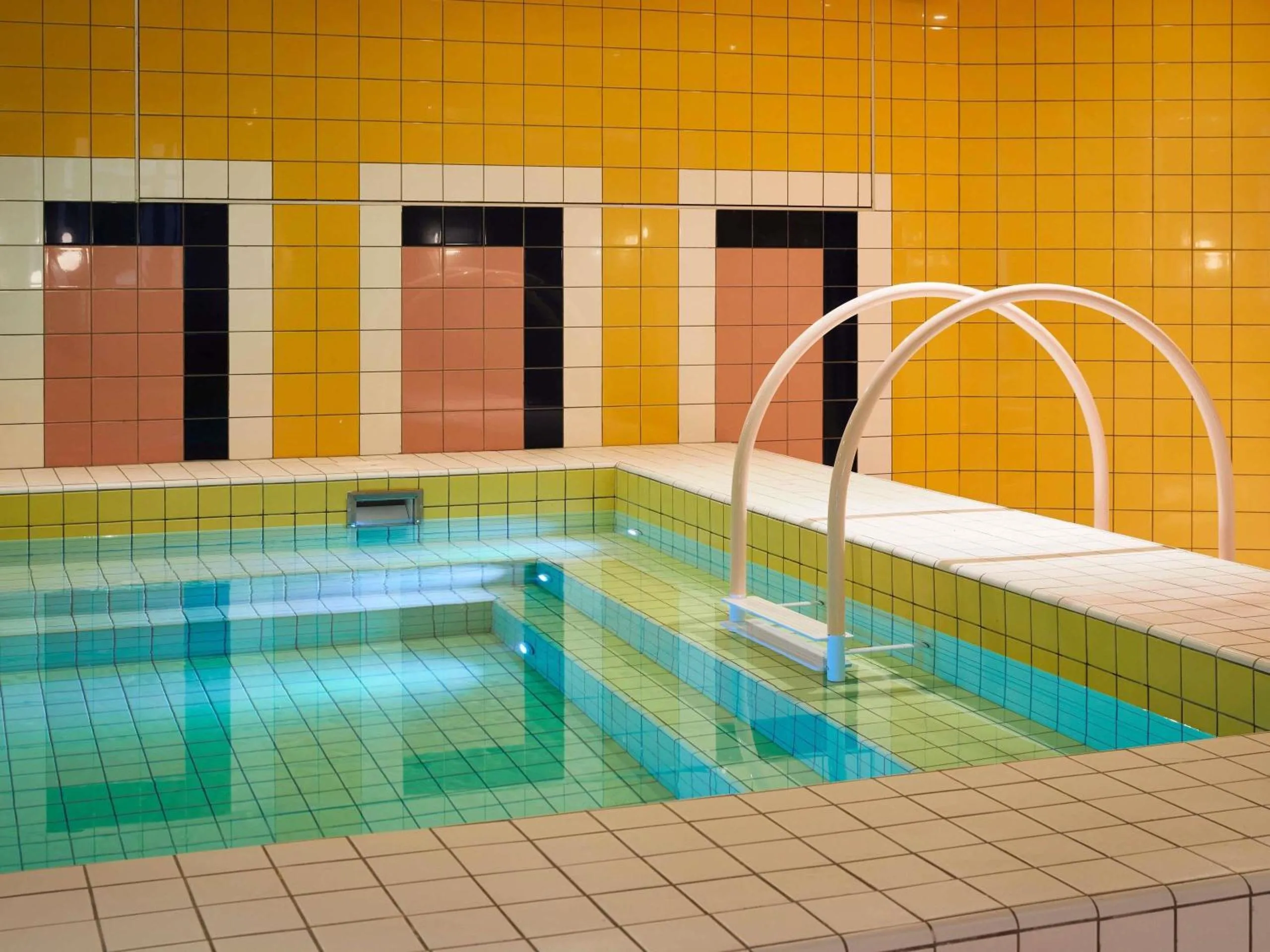 Mama Shelter Roma indoor pool with bold yellow, pink and black graphic-tiled walls