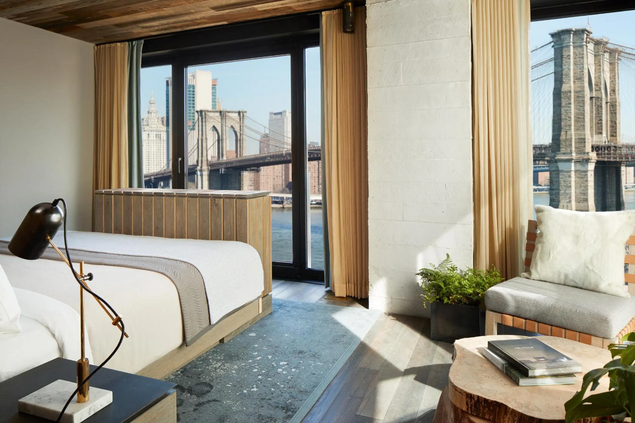 1 Hotel Brooklyn Bridge bedroom with desk, city skyline view and greenery