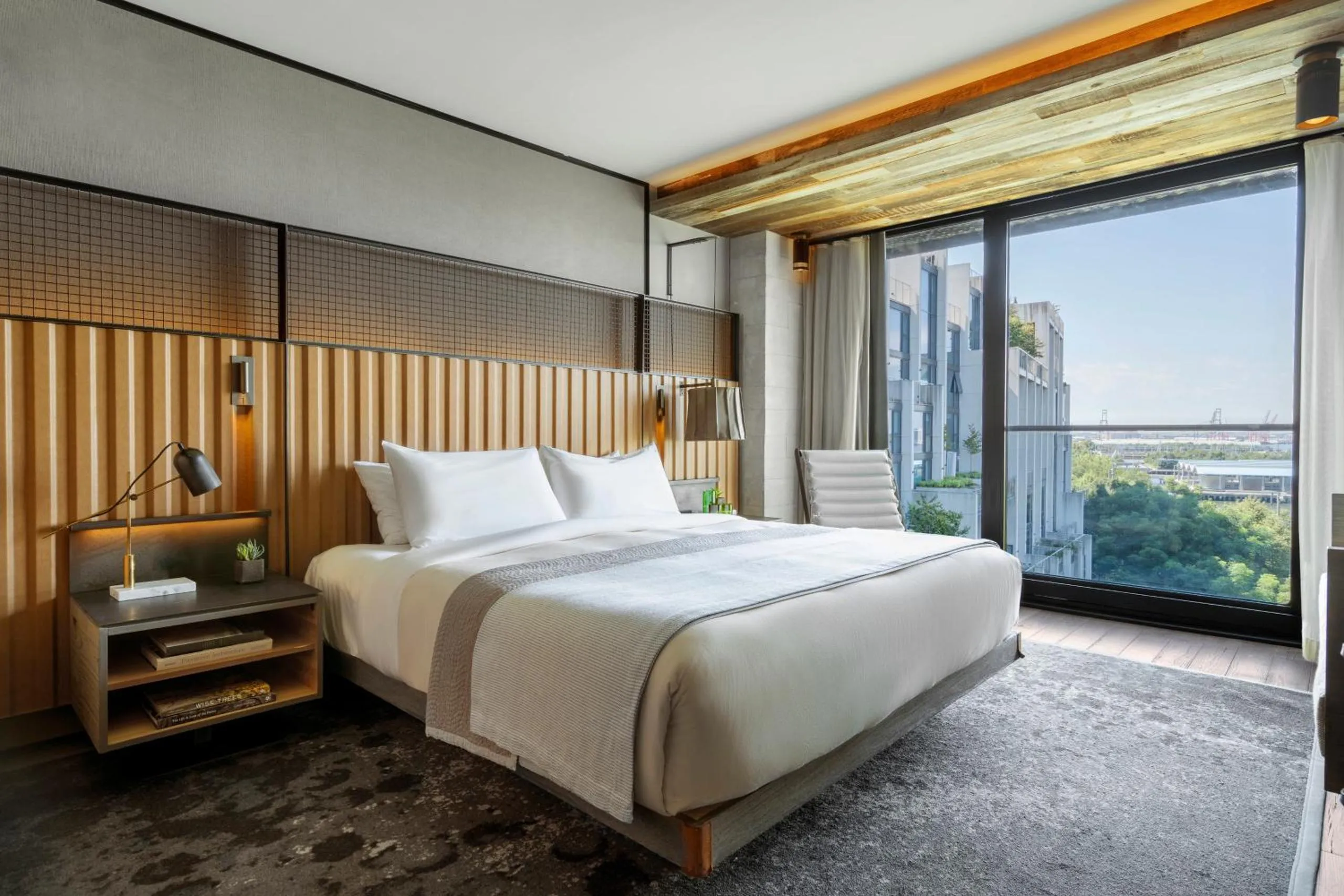 1 Hotel Brooklyn Bridge bedroom with wooden headboard and waterfront view
