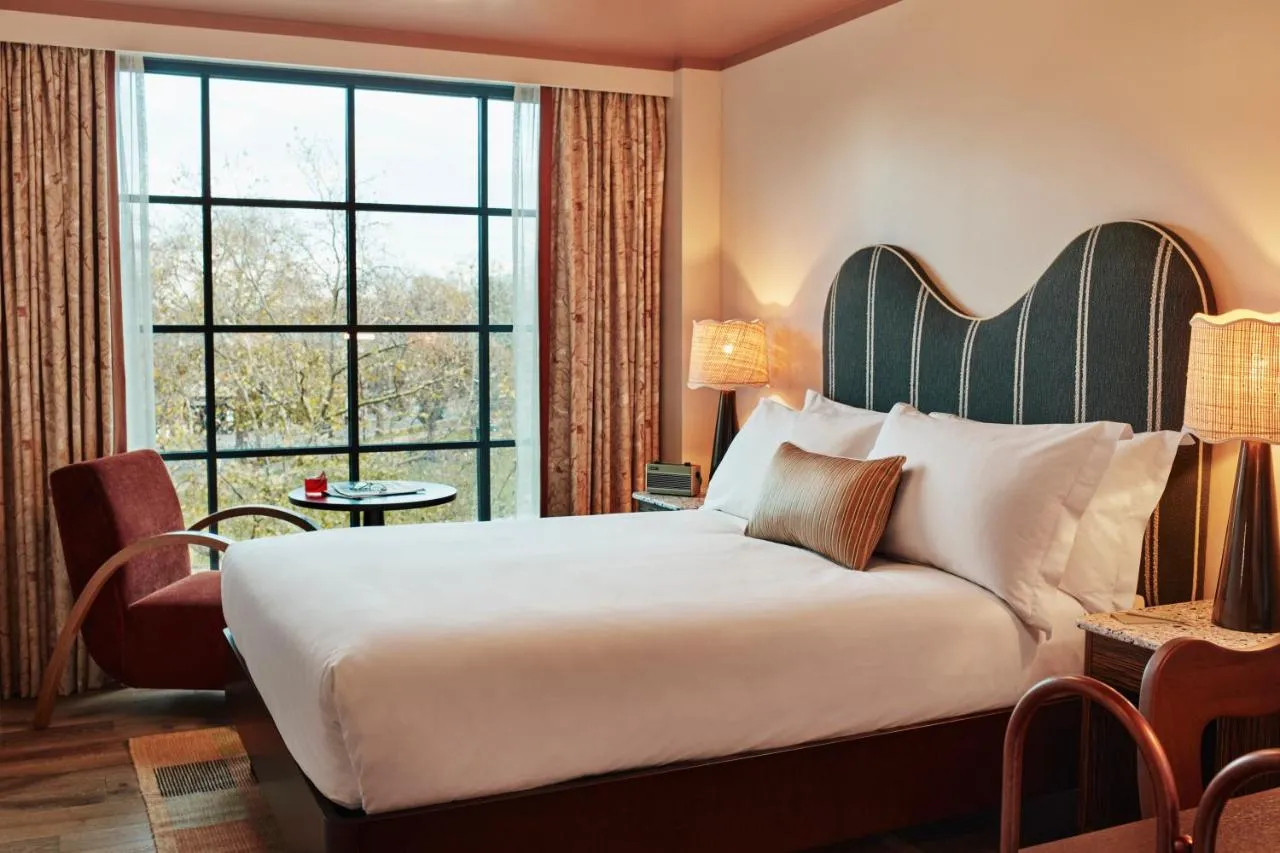 The Hoxton Shepherd's Bush boutique hotel - bedroom with a scalloped green headboard and large windows