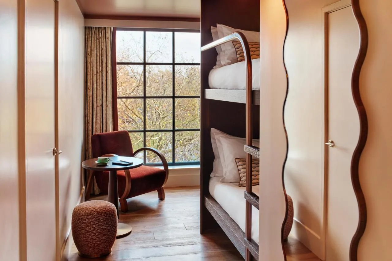 The Hoxton Shepherd's Bush boutique hotel - bunk beds beside a wavy-panelled wardrobe and window desk