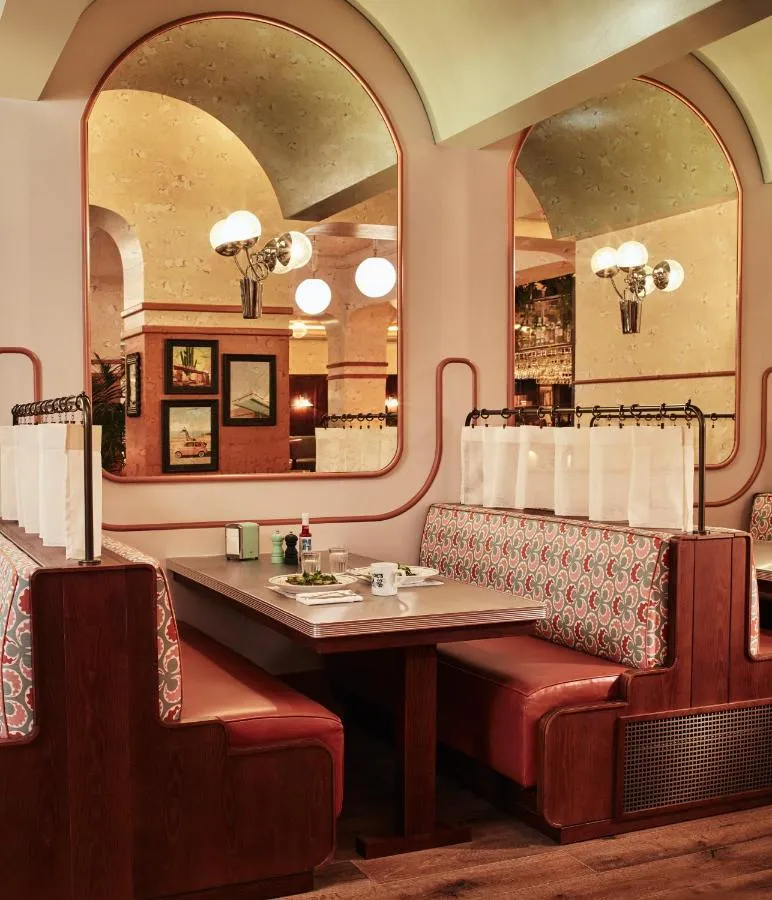 The Hoxton Shepherd's Bush boutique hotel - restaurant booth seating beneath arched mirrors