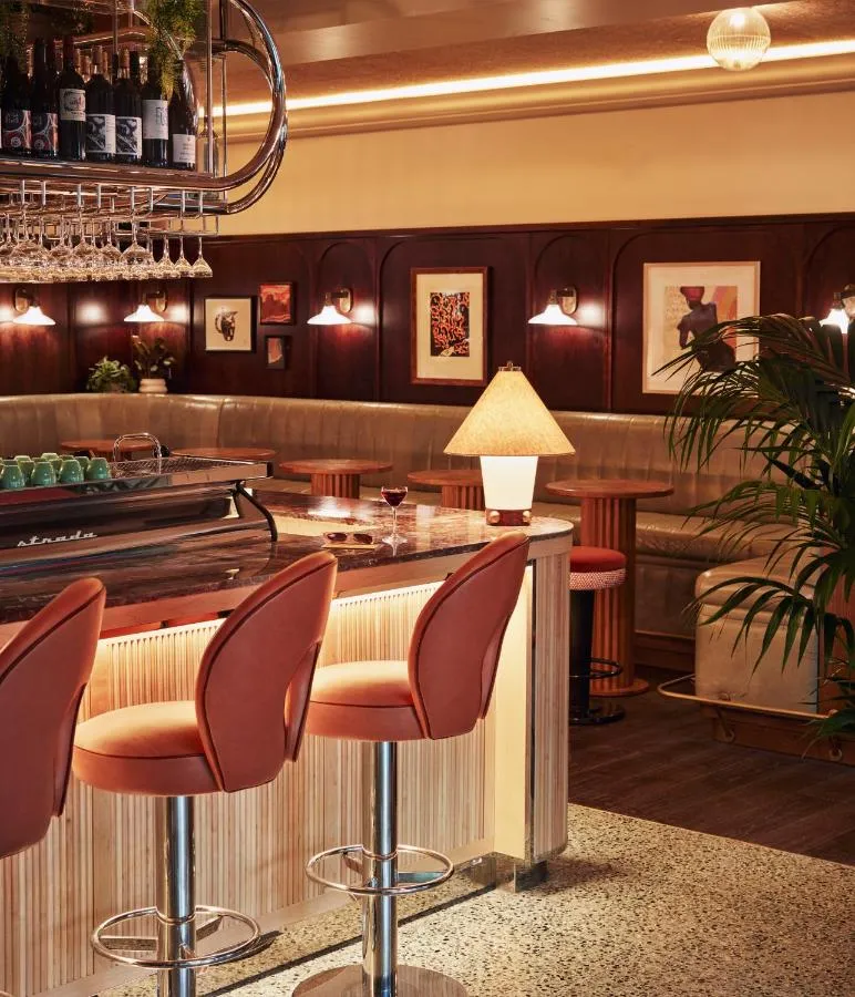 The Hoxton Shepherd's Bush boutique hotel - wood-panelled bar with red banquette seating