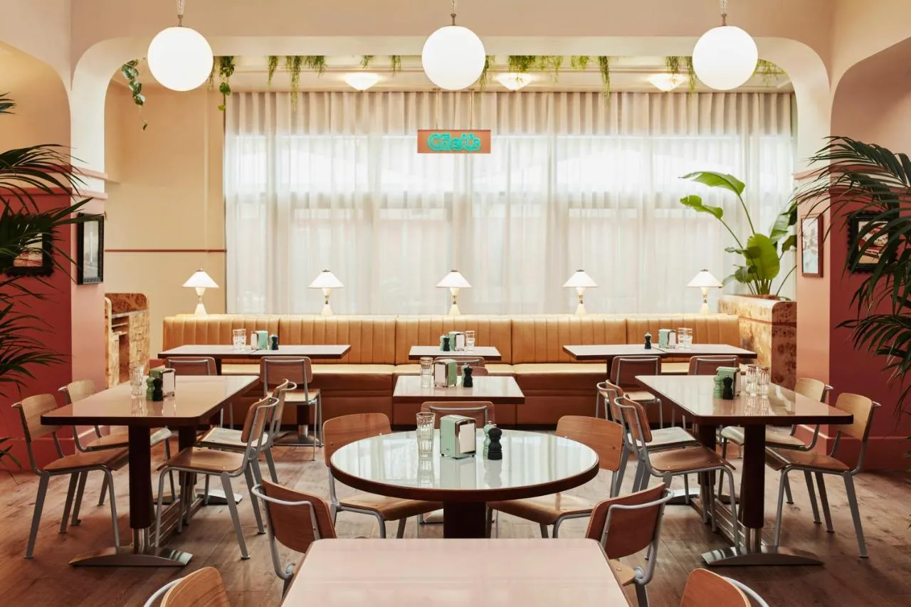 The Hoxton Shepherd's Bush boutique hotel - diner with round marble tables and globe pendant lights