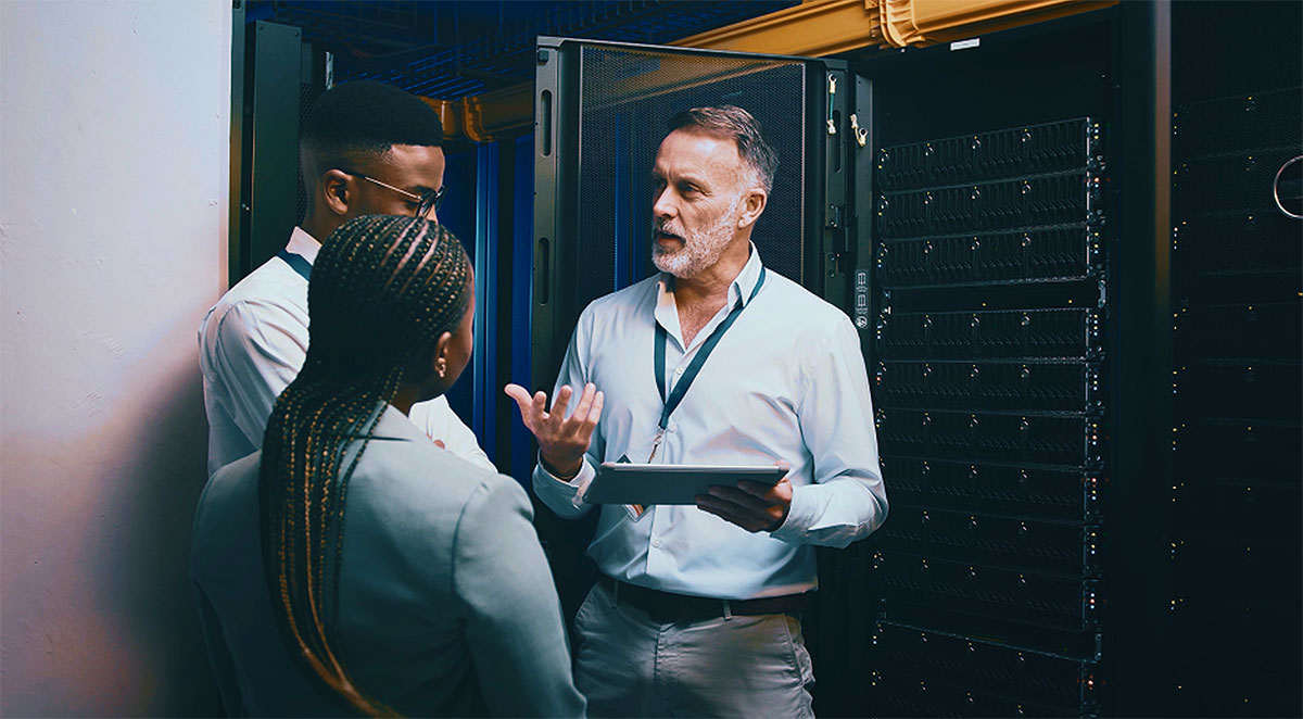 Team discussing server equipment inside a data center.