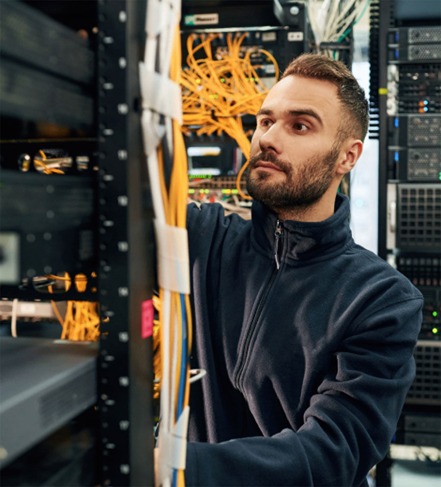 Technician managing network cables in a data center.