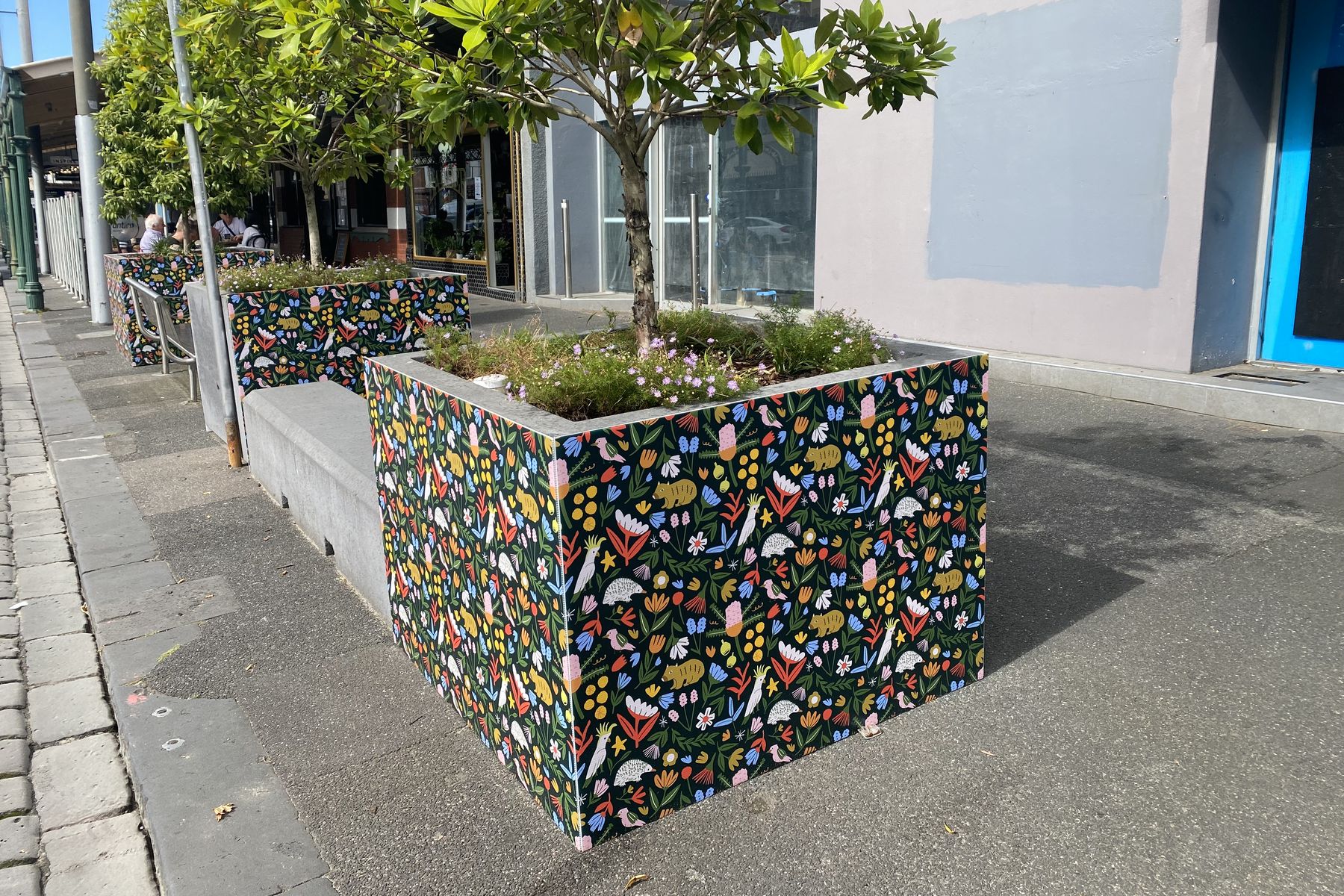 Street planter boxes wrapped in colourful printed pattern graphics