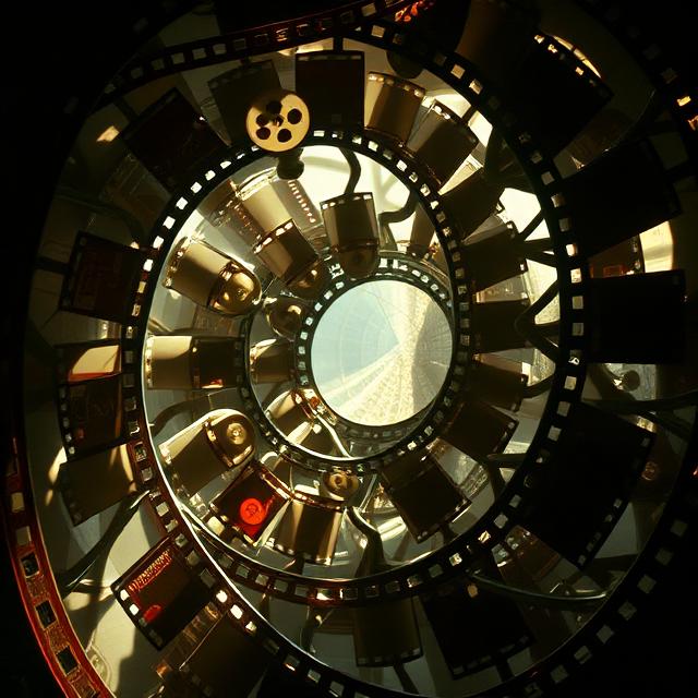 Film clapperboard with popcorn spilling out on a yellow background.