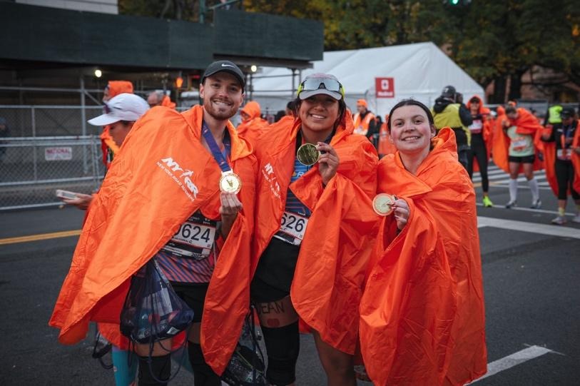 A group of people wearing orange capesAI-generated content may be incorrect.