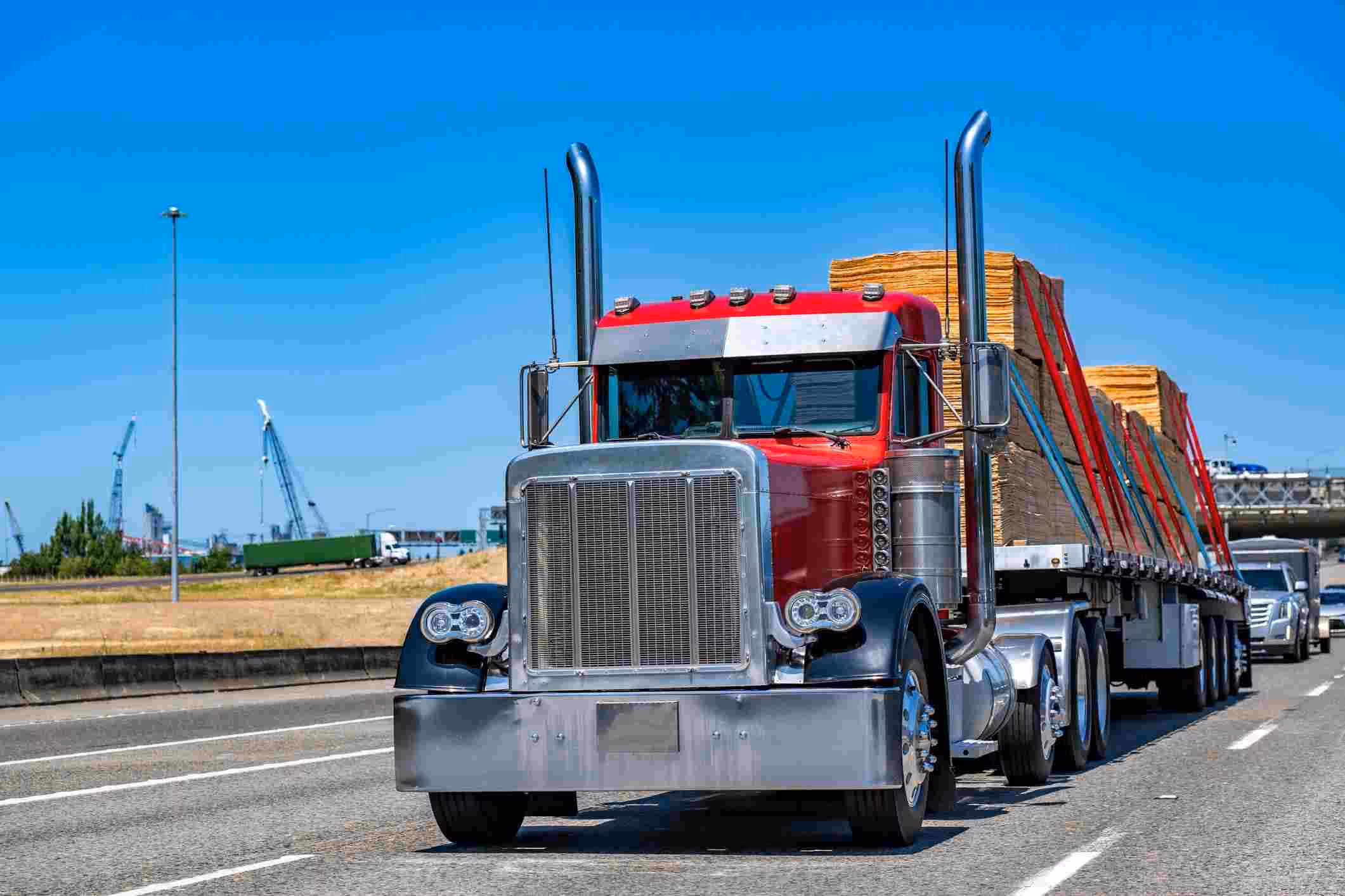 A red semi-truck on a rural highway, symbolizing the expertise of a Fulshear truck accident lawyer in handling big rig collision cases.
