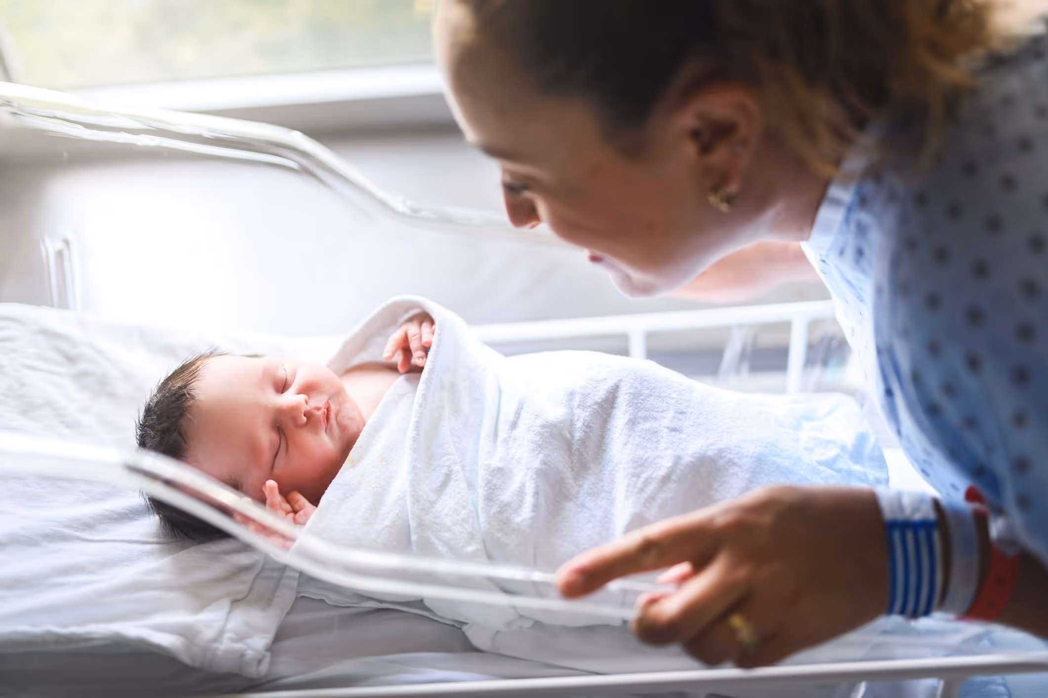 Newborn baby in hospital bassinet, highlighting the need for an infant brain injury lawyer after signs of brain damage at birth.