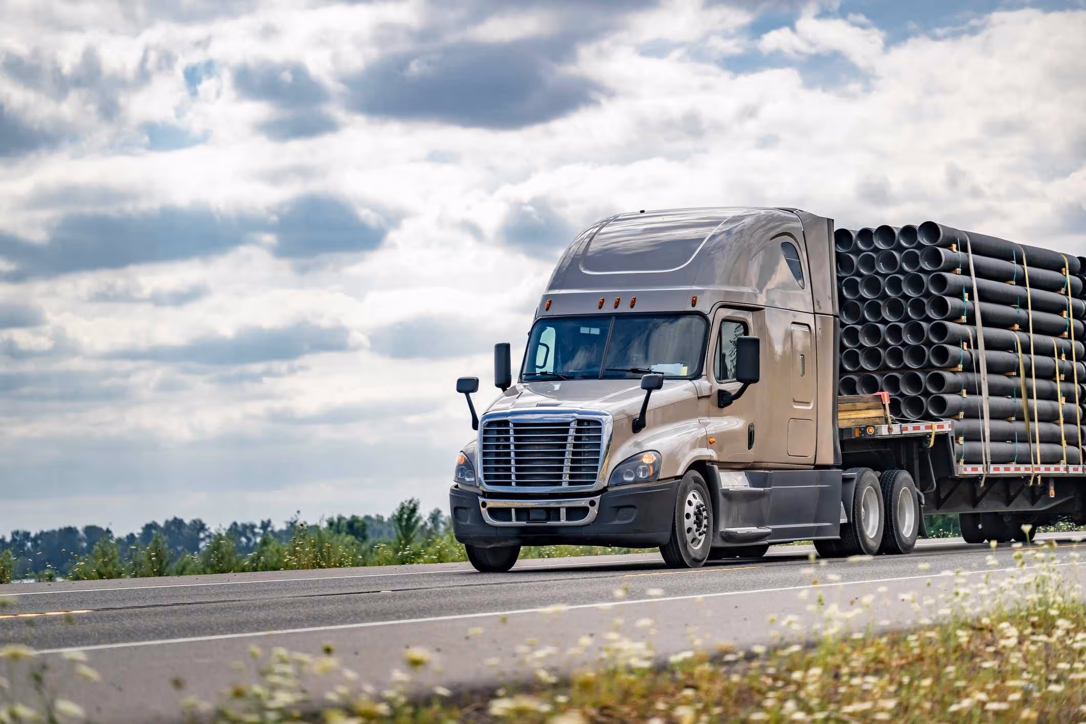  Big rig transporting pipes on Texas highway, related to a Cypress truck accident lawyer case.