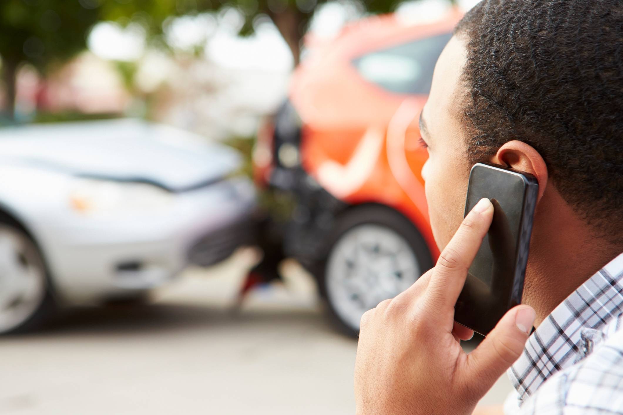 Male driver calling for help after collision, representing a Friendswood car accident lawyer.