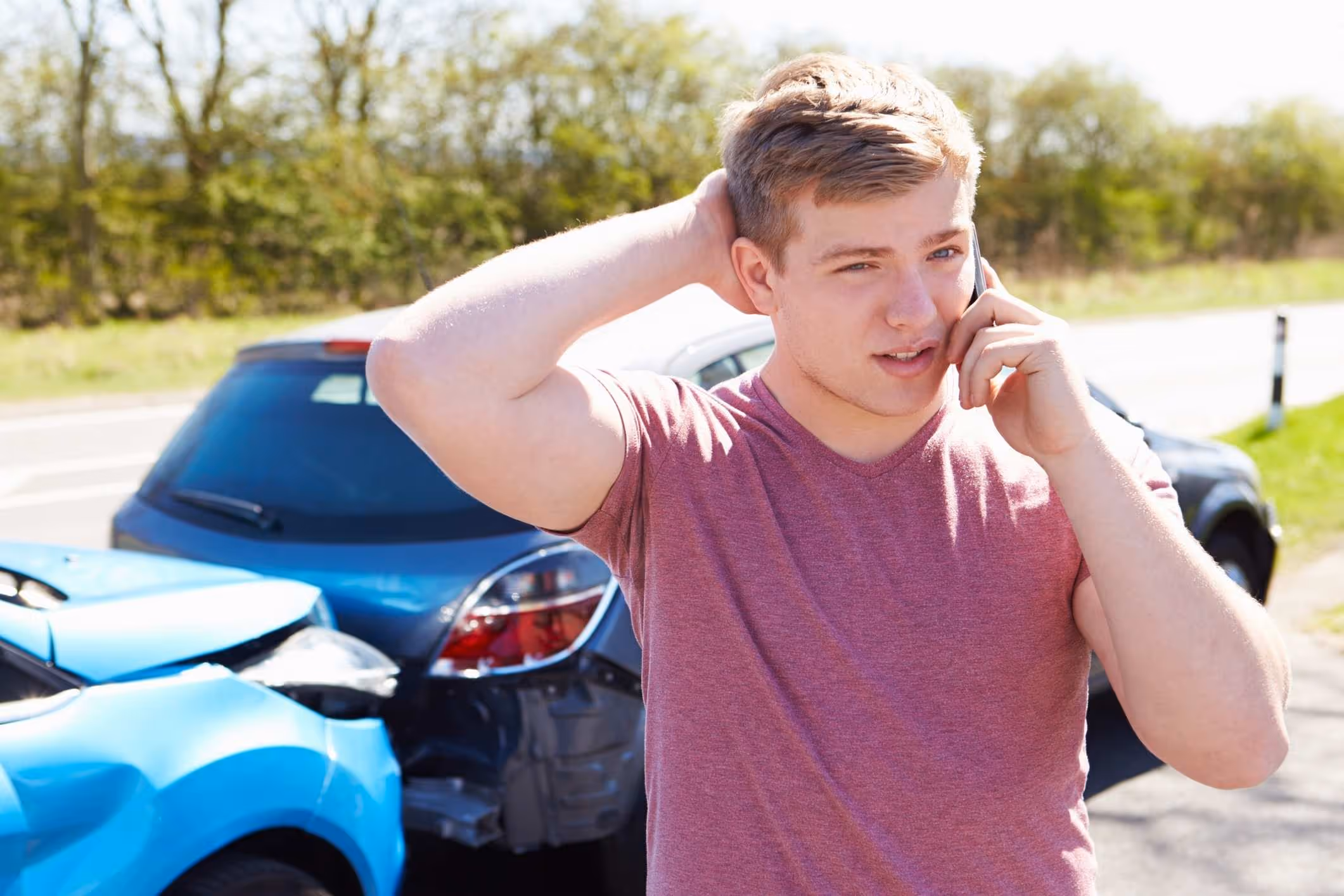  Man on phone at accident scene, representing need for a La Porte car accident lawyer.
