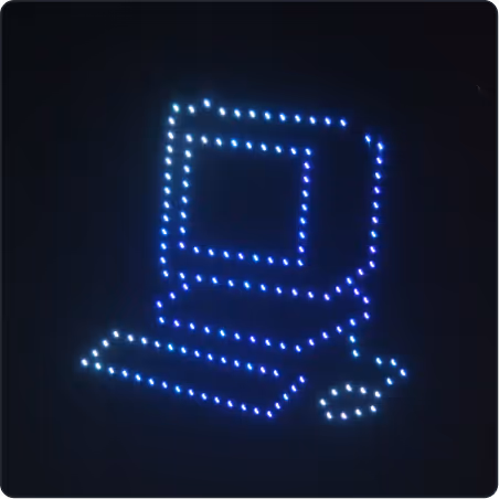 Blue and white LED lights forming the shape of a desktop computer with a monitor, keyboard, and mouse on a dark background.