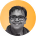 Smiling person with short dark hair and glasses against an orange circular background.