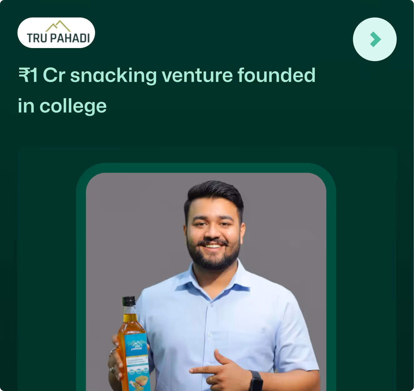 Man in a light blue shirt smiling and holding a bottle of snack product with Tru Pahadi label.