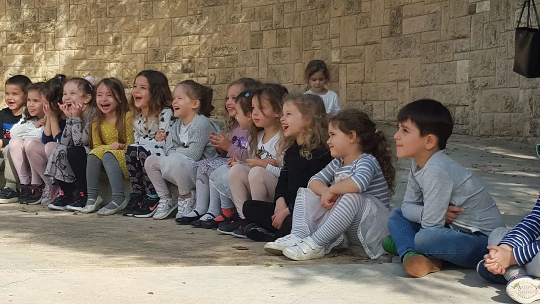 ילדים יושבים מרותקים במופע קסמים