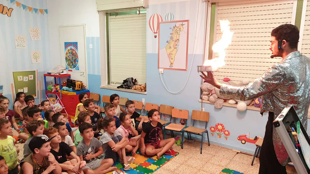 קוסם עושה קסם עם אש בהופעת יום הולדת