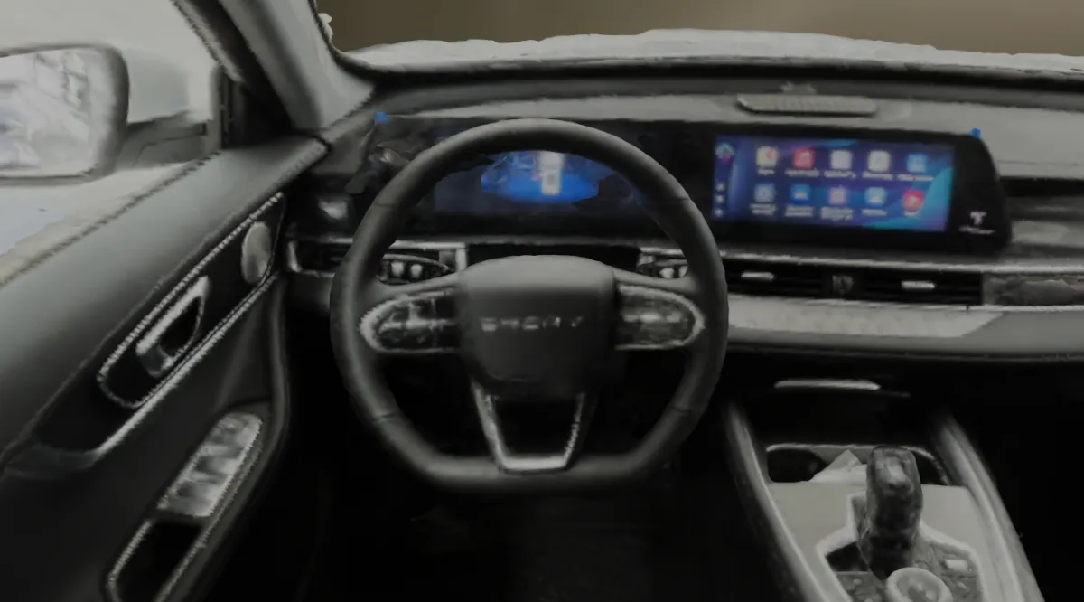 The image shows the interior of a car, focusing on the steering wheel, dashboard, and central touchscreen. The design is modern with a sleek, digital display on the dashboard.