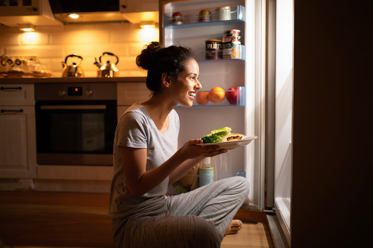 Woman looking for a nutritious snack in a fridge
