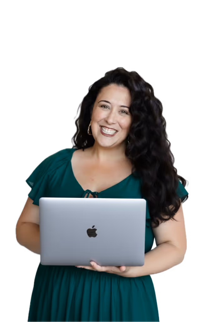Lizzy Moffett smiling, holding silver MacBook in teal dress