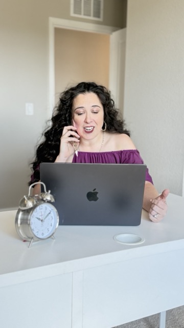 Lizzy Moffett on the phone with a client while working at the computer