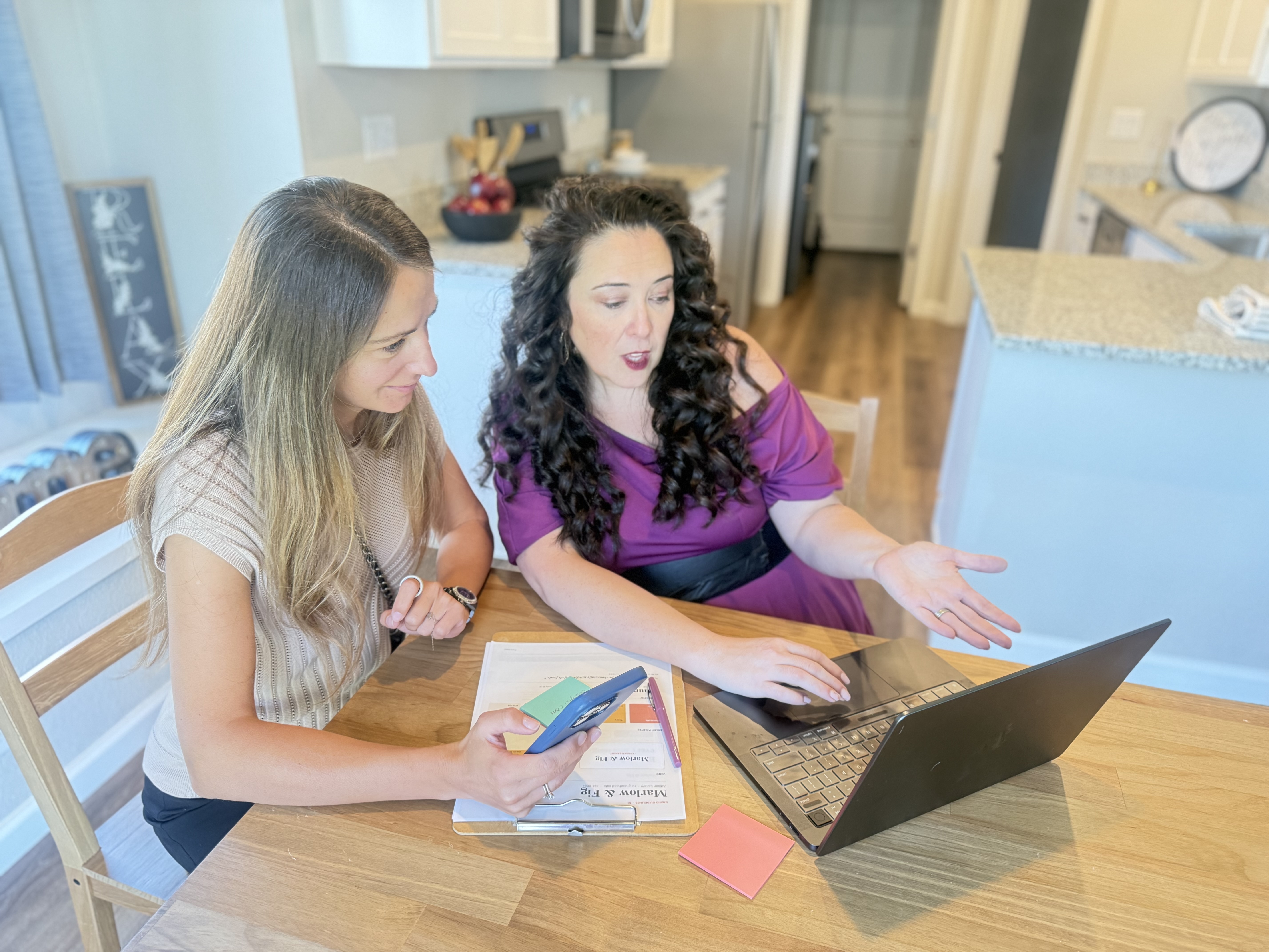 Lizzy Moffett sitting at a dining room table, planning a website with a client